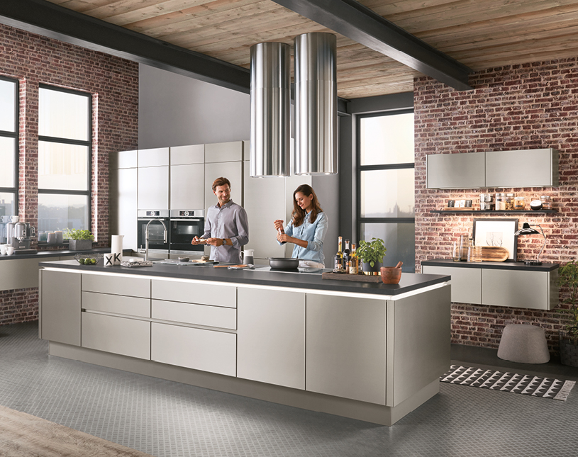moderne graue Küche in Loftwohnung mit kochendem Paar