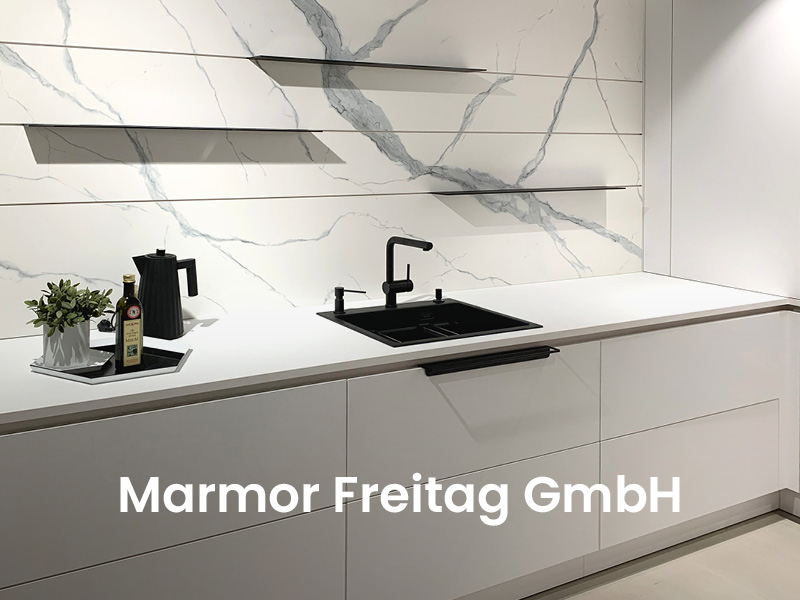 Bild zeigt weiße Küchenzeile mit Marmor-Rückwand von Marmor Freitag GmbH