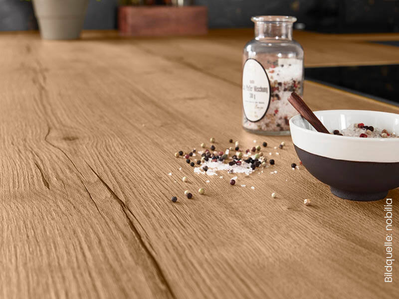 Fokus auf Küchenarbeitsplatte aus Holz mit Schüssel und Pfefferkörnern