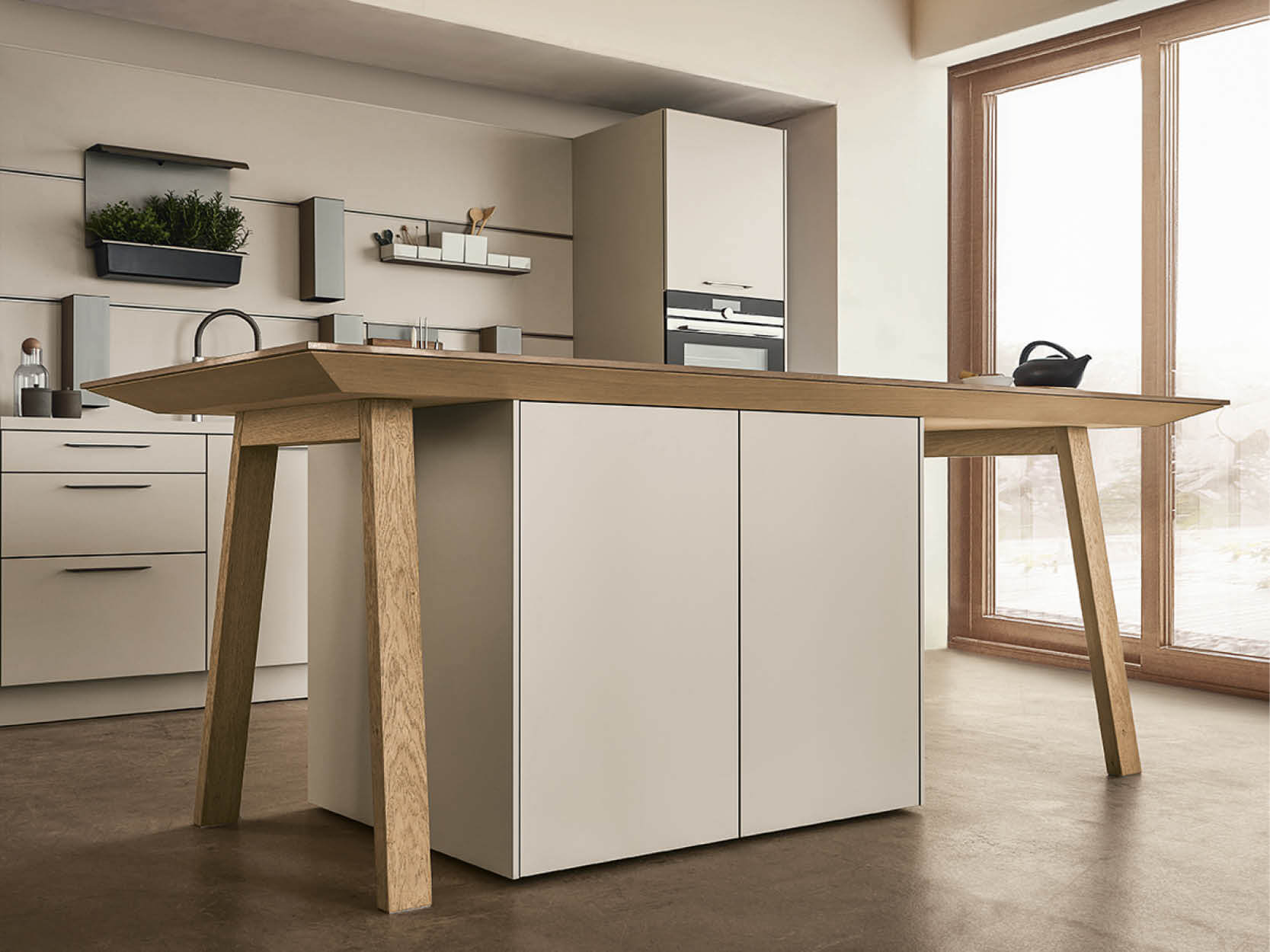Kochtisch von next125 mit Holzbeinen und Möbeln mit weißen Fronten in warmen Ambiente
