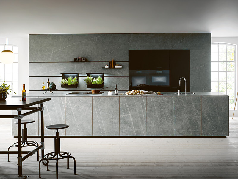 graue Inselküche in Marmoroptik von next125 mit Wandpaneelen