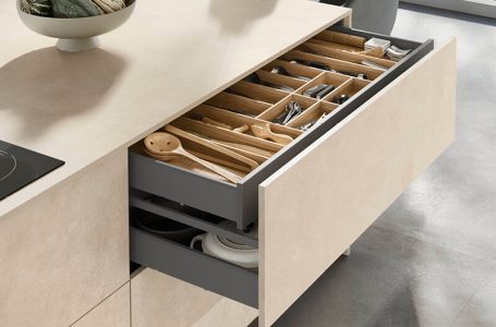 Kücheninsel mit Blick auf geöffnete Schublade mit hellen, fein strukturierten Fronten
