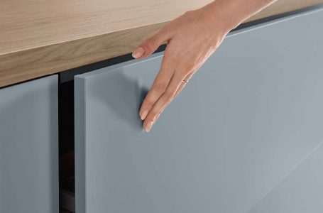 Matte Küchenfront, auf der eine Hand liegt.