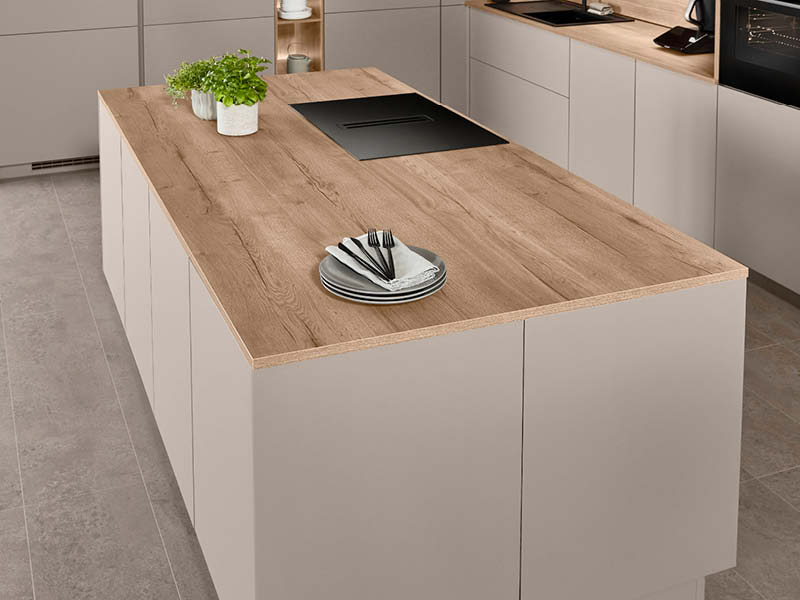 Matte Küche in Cremefarben mit Holzarbeitsplatte und mattem Kochfeld.