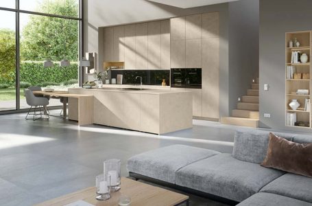 loftartiger Raum mit beige Küche, Ess- und Wohnbereich in natürlichen Farbtönen