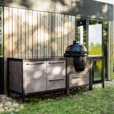 Modulare Burnout Outdoor-Küche in Grau mit Keramikfronten, Big Green Egg, Stauraum und Arbeitsfläche im Garten am modernen Haus.
