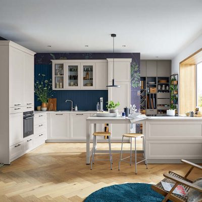 Moderne Landhausküche in Creme mit Kochinsel, Holzarbeitsplatte, Stauraum, Einbaugeräten und gemütlichem Wohnbereich.