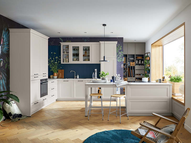 Moderne Landhausküche in Creme mit Kochinsel, Holzarbeitsplatte, Stauraum, Einbaugeräten und gemütlichem Wohnbereich.