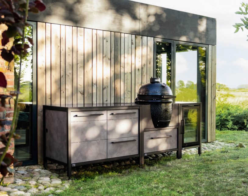 Outdoor-Küche von BURN vor Holzhausfassade in grüner Umgebung
