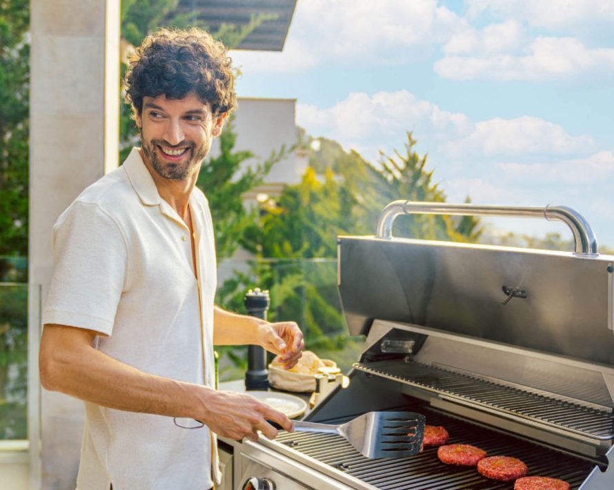 gut gelaunter Mann bereitet Burgerpads in Outdoorküche von BURN zu