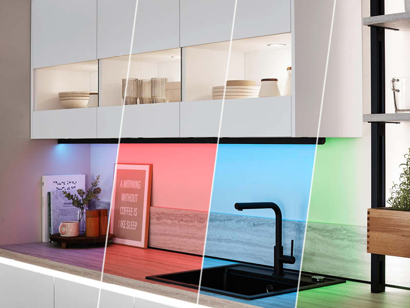 Weiße Küche mit Glasoberschränken und farbiger LED-Rückwandbeleuchtung in Rot, Blau und Grün für moderne Akzentbeleuchtung am Herd.