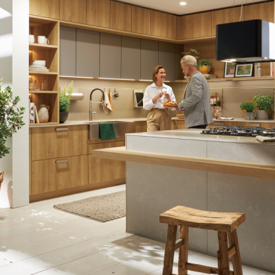 Paar in einer modernen Küche mit Holzfronten und Kücheninsel – gemeinsames Kochen und wohnliche Küchenatmosphäre bei SPECHT Küchen.