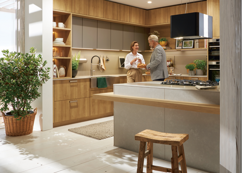 Paar in einer modernen Küche mit Holzfronten und Kücheninsel – gemeinsames Kochen und wohnliche Küchenatmosphäre bei SPECHT Küchen.